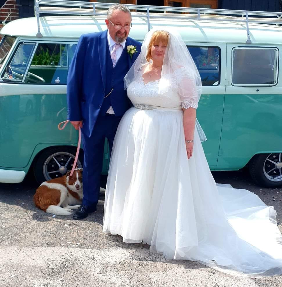 bride and groom with dog stood in front of campervan